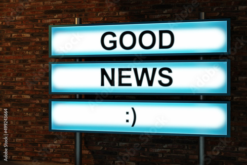 Good news in black letters on a light box. The illuminated sign placed in front of a red brick wall. Good news from the family, school or, breaking news or the job for instance. 3D illustration