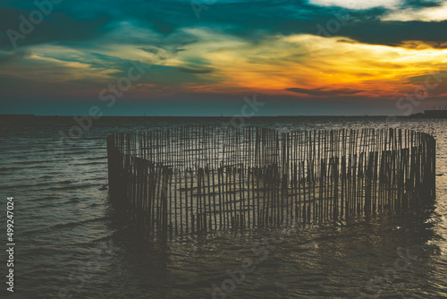 Sunset or evening time at sea or ocean at Bang poo, Samutprakan, Thailand. with bamboo shape of heart. photo