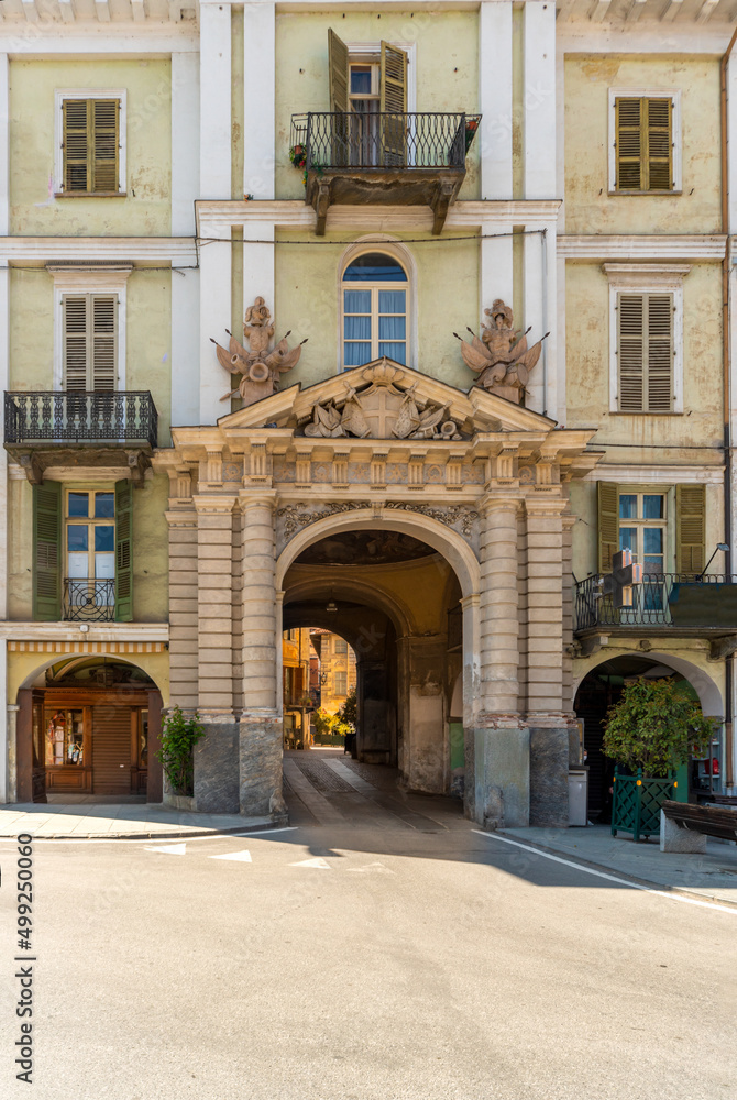 Saluzzo, Cuneo, Italy - April 15, 2022:  historic building with the Porta Santa Maria, gateway to the old city, con columns  of Renaissance style with tympanum with the Savoy coat of arms