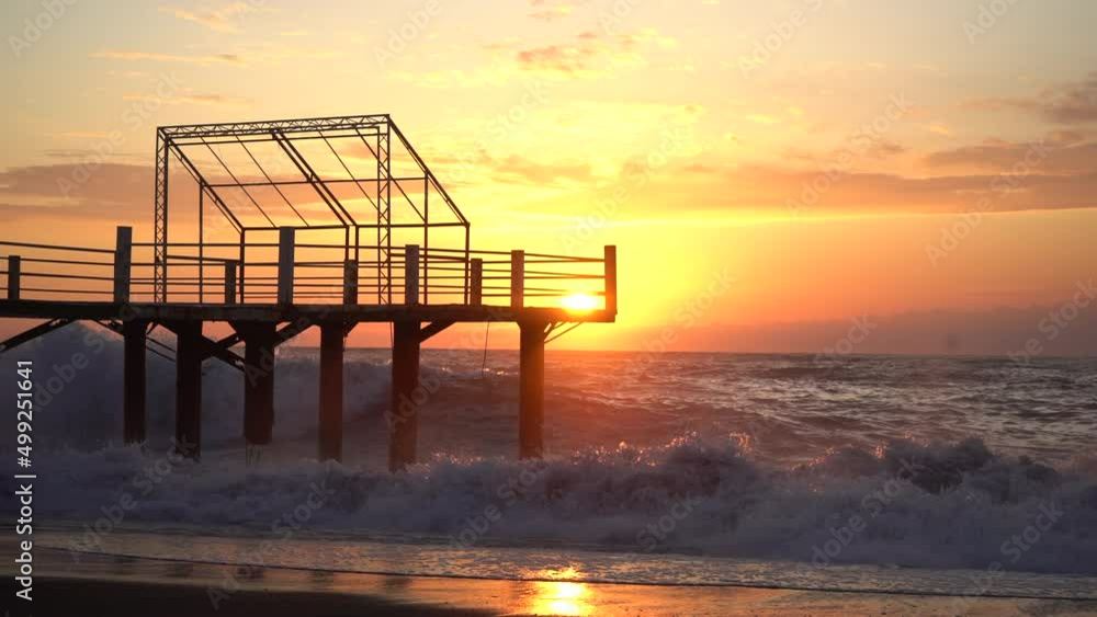 Beach shore with pebbles, sand on the sunset with waves crushing on shore in the background. Old pier. High quality 4k footage Beach shore with pebbles, sand on the sunset with waves crushing on shore in the background. Old pier. High quality 4k footage