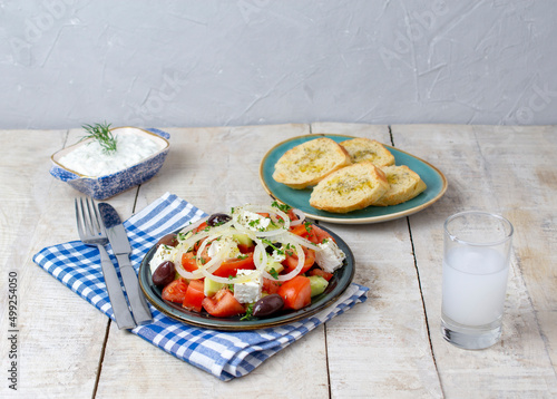 Greek salad with tzatziki, olives and feta cream. Traditional salad, meze, with olive oil. Ouzo or Raki and traditional greek salad, tzatziki and olives