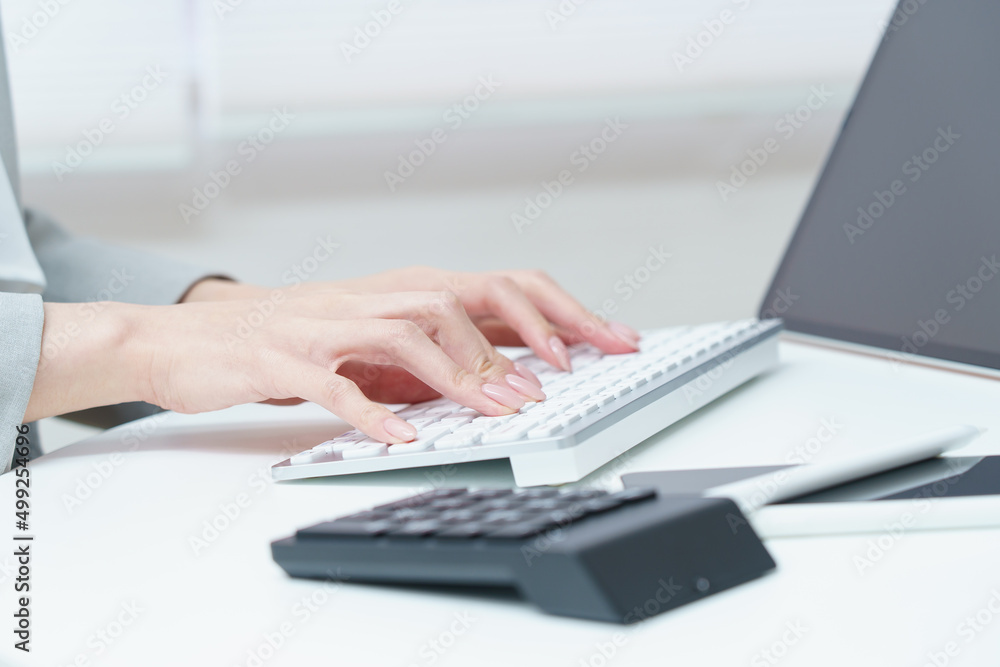 A woman's hand hitting a computer keyboard A woman's hand hitting a computer keyboard