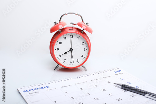 alarm clock with calendar. alarm clock with calendar on the background. Busy work reminder, annual leave, project deadline or memo text concept 