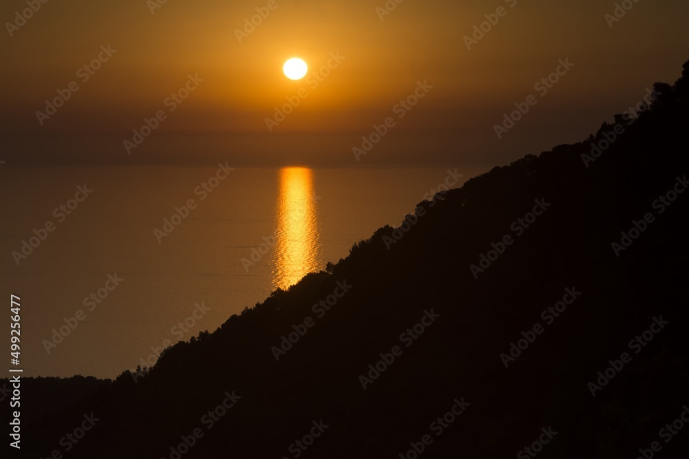 Setting sun over the landscape, reflection of the sun in the sea, view from Esporles, silhouette. Mallorca, Balearic Islands, Spain.