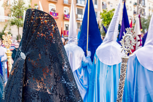 Detail of the head of a woman with a black spanish mantilla and peineta (ornamental comb), seen from behind, in a Holy Week procession photo