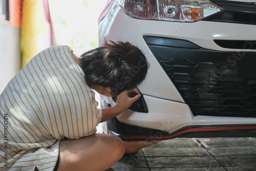 looking at a damaged vehicle. Woman inspects car damage after an accident car paint photo