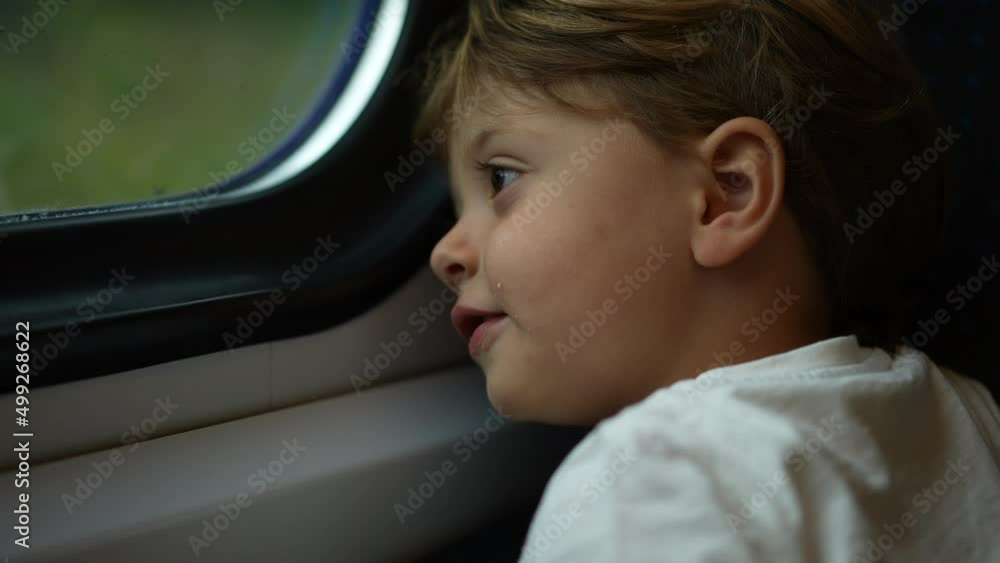 Little boy leaning on train window looking at landscape passing by Little boy leaning on train window looking at landscape passing by