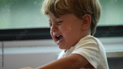 Little boy having a tantrum while traveling by train child crying uncontrollably on a trip photo