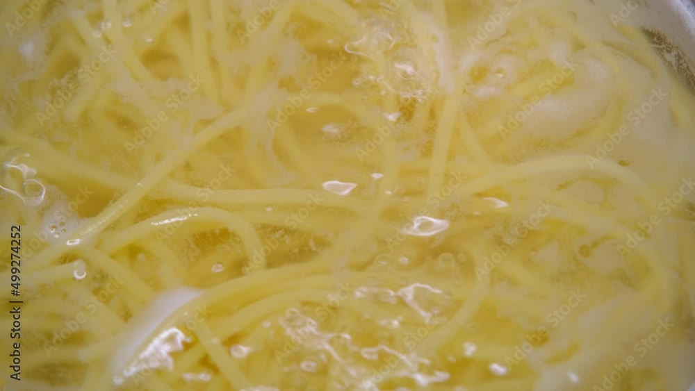 Close-up of spaghetti pasta in boiling hot water in steel pot. Cooking at home. Preparation for making homemade Spaghetti Carbonara. Close-up of spaghetti pasta in boiling hot water in steel pot. Cooking at home. Preparation for making homemade Spaghetti Carbonara.