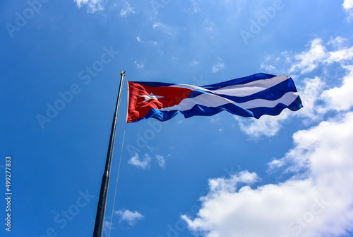 The Cuban flag flutters in the wind against a blue sky. National symbol. Cuba. Havana. March 27, 2019.