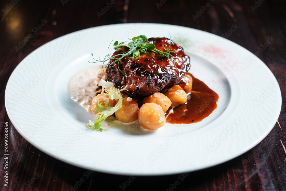  Steak grilled with potatoes and sauce.