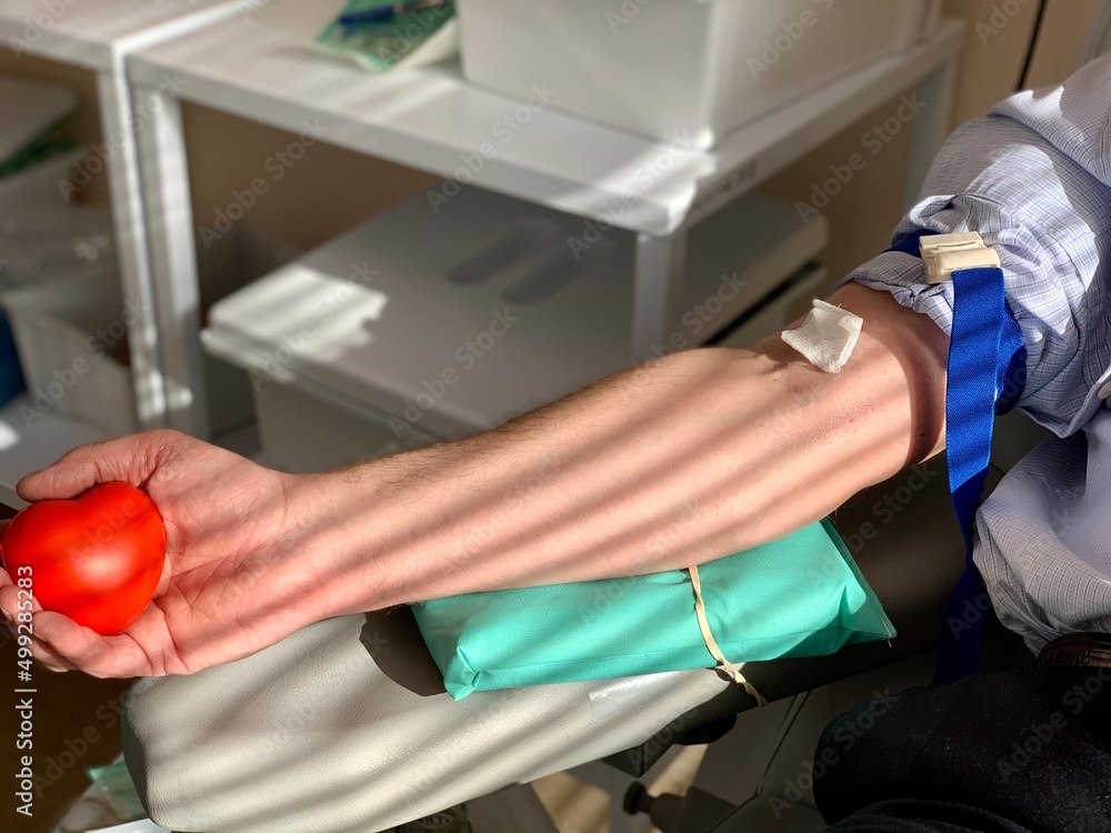 Blood donor, gives blood in the laboratory. Preparing for taking blood from the vain. Arm pressing a ball for better blood pressure. Blood donor, gives blood in the laboratory. Preparing for taking blood from the vain. Arm pressing a ball for better blood pressure.