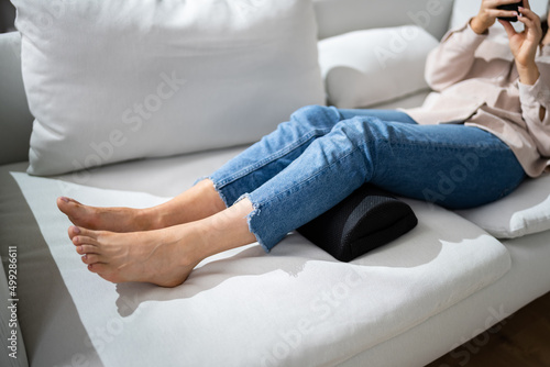 Woman Using Footrest To Reduce Back Strain