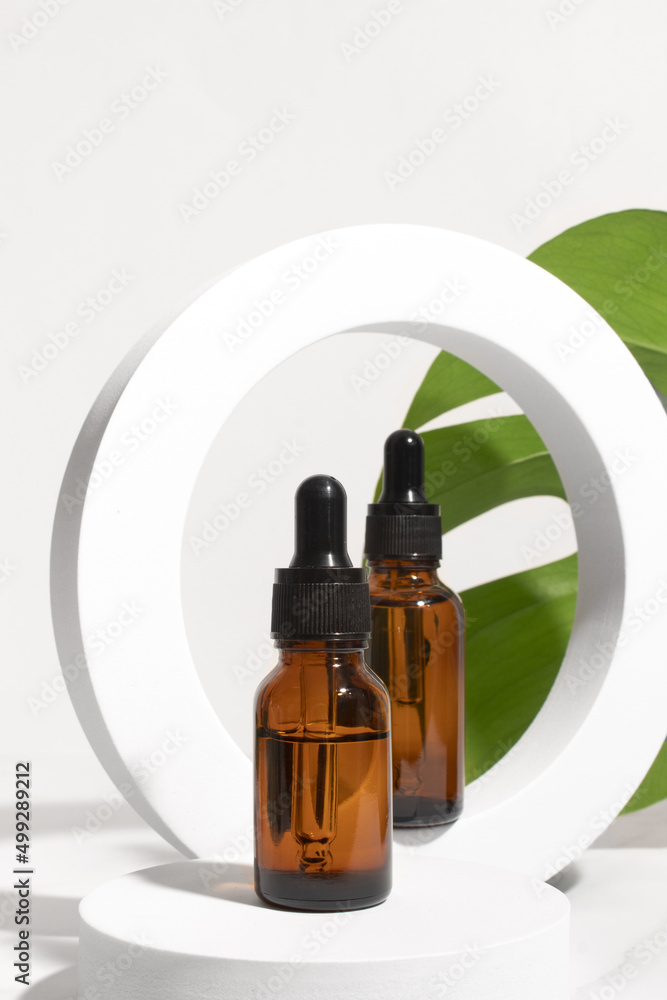 Dropper bottle with monstera palm leaf. Aromatic oil container, medical packaging template. Herbal cosmetic concept. Dropper bottle with monstera palm leaf. Aromatic oil container, medical packaging template. Herbal cosmetic concept.