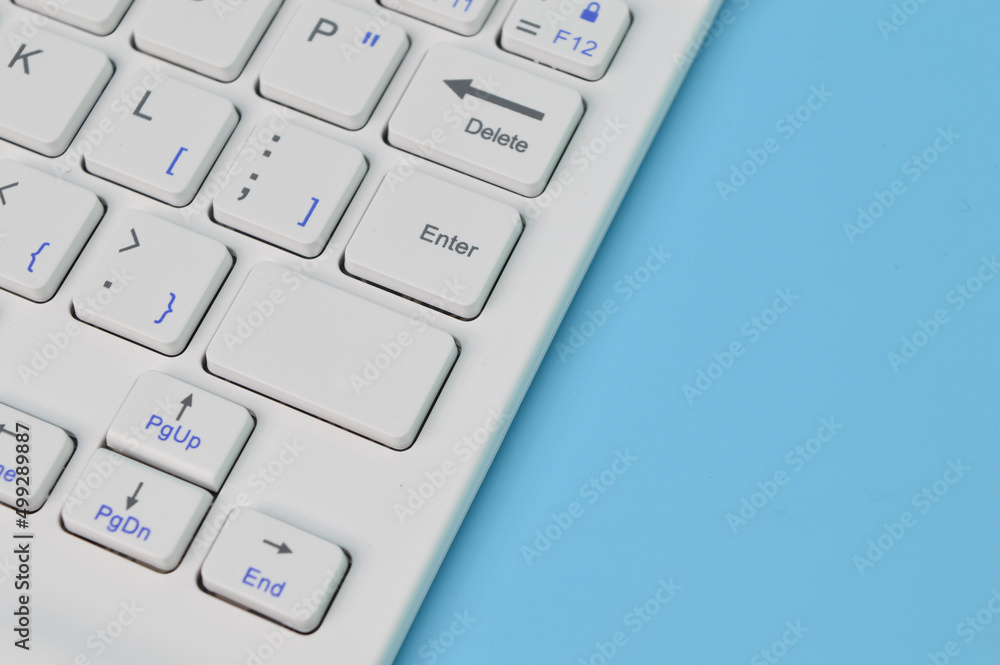 Close up view of computer keyboard isolated on a blue background. Copy space for the text. Close up view of computer keyboard isolated on a blue background. Copy space for the text.