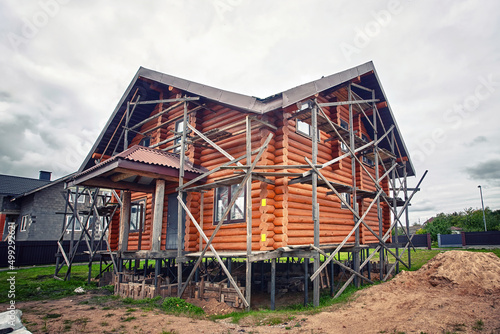 Wooden house architecture. House built from logs. Wooden log house. Log cabin, permanent wood foundations under construction. House on pile foundation.