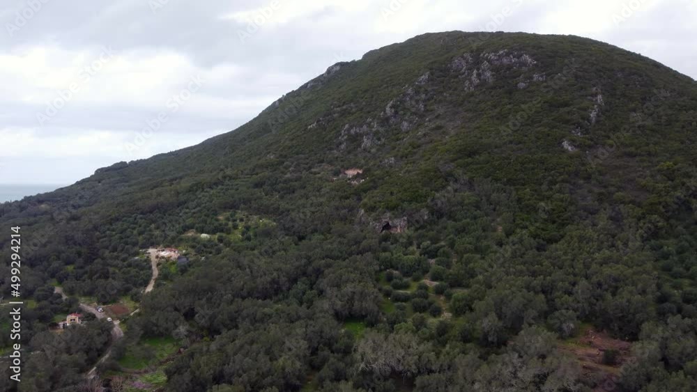 Perfect aerial view flight long fly forwards drone footage to a big cave in a mountain in the wild nature Corfu wait for explorer in Greece. 4k Cinematic view from above by Philipp Marnitz spring 2022 Perfect aerial view flight long fly forwards drone footage to a big cave in a mountain in the wild nature Corfu wait for explorer in Greece. 4k Cinematic view from above by Philipp Marnitz spring 2022