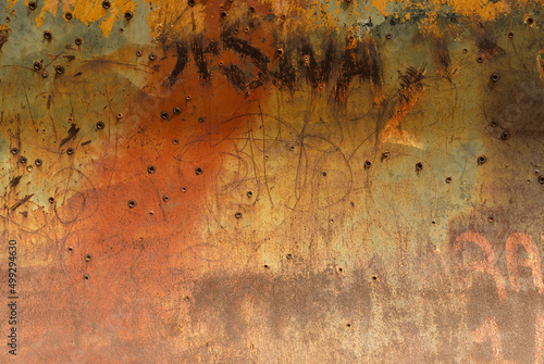 Rusty metal plate with bullet holes photo