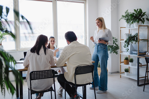 Concentrated colleagues looking at their female business partner