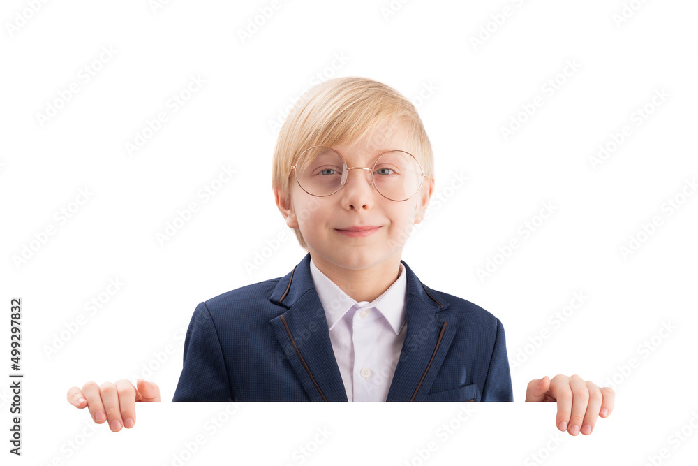 Smiling boy with empty white paper board and laughs. Cute blond boy peeking out from behind white board. Space for text Smiling boy with empty white paper board and laughs. Cute blond boy peeking out from behind white board. Space for text