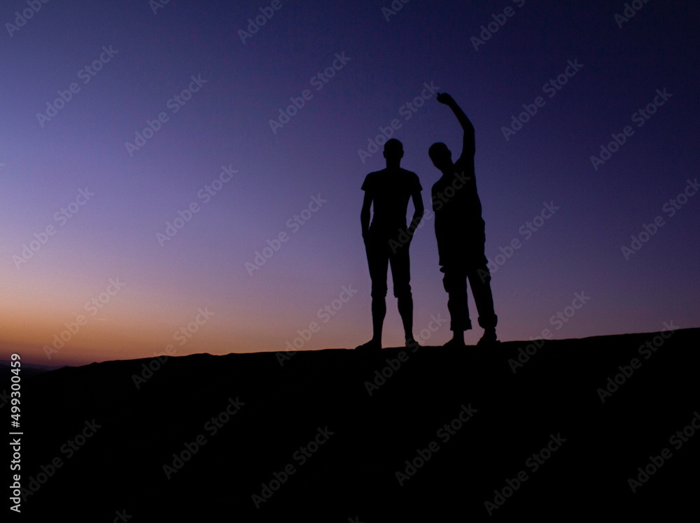 silhouette In a place full of sand in Nizwa and Two guys enjoying the place