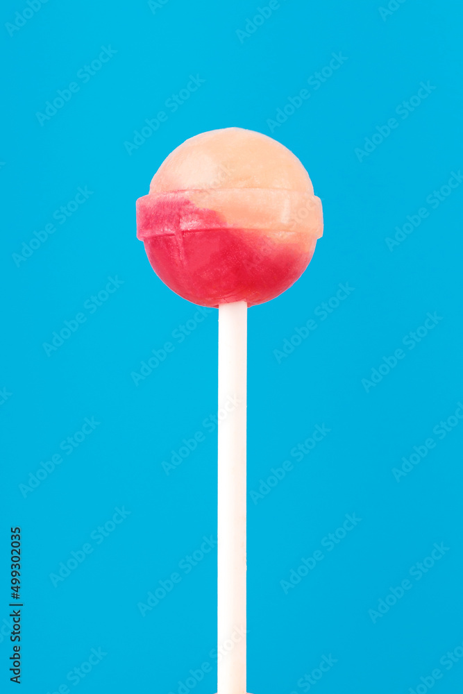 Multi-colored candies on a stick, blue background.Many colorful lollipops (Chyupa-Chyups) on a blue background Multi-colored candies on a stick, blue background.Many colorful lollipops (Chyupa-Chyups) on a blue background