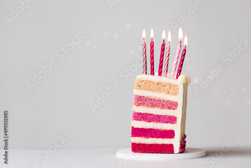 Slice of pink ombre birthday cake with candles