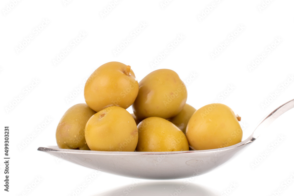 Several green pitted olives on a metal spoon, macro, isolated on white. Several green pitted olives on a metal spoon, macro, isolated on white.