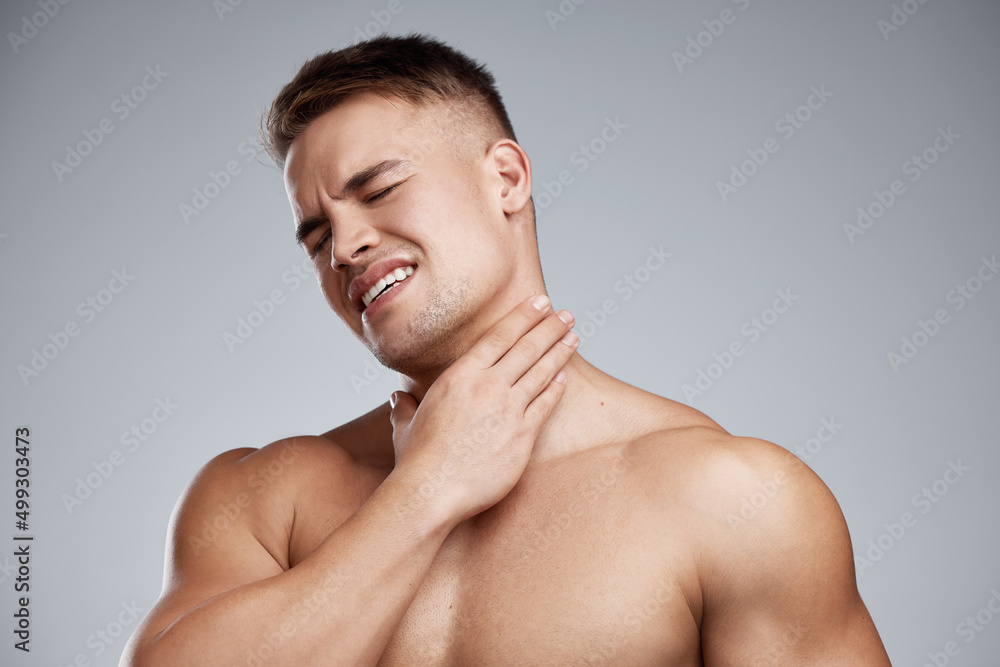 I went too far this time. Studio shot of a muscular young man experiencing neck pain against a grey background. I went too far this time. Studio shot of a muscular young man experiencing neck pain against a grey background.