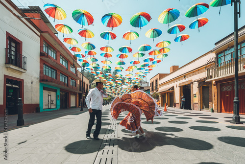 Dancers of typical Mexican dances from the central region of Mexico, doing their performance in the street adorned with colored umbrellas.