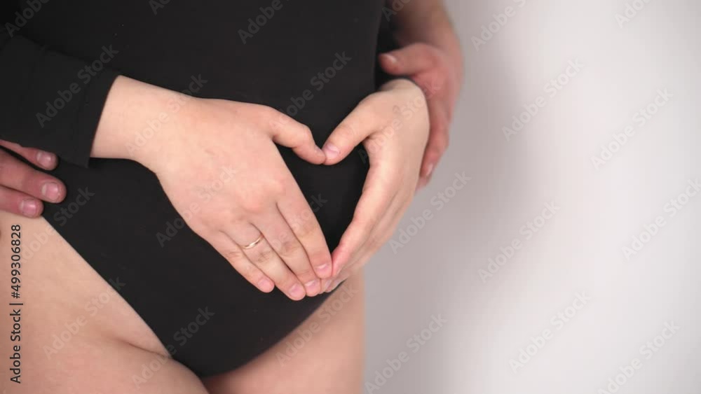 Happy pregnant woman with big belly resting at home. Pregnant young woman with a man expecting a baby. Young expectant mother caresses her belly. The young family is waiting for replenishment. Happy pregnant woman with big belly resting at home. Pregnant young woman with a man expecting a baby. Young expectant mother caresses her belly. The young family is waiting for replenishment.