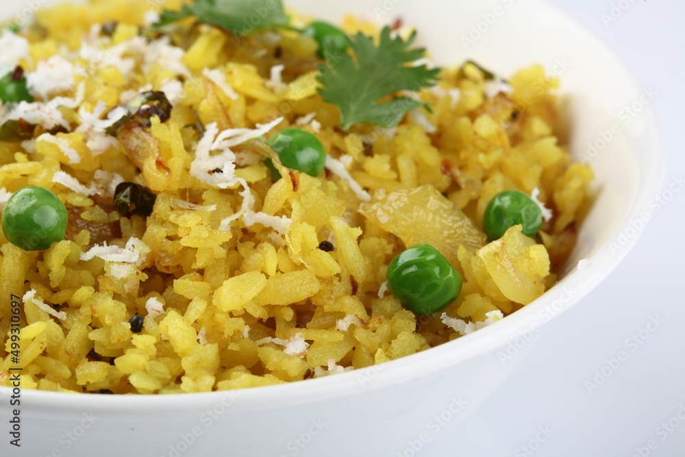 Kande Pohay OR Aloo Pohe is a popular Indian breakfast recipe made using Flattened rice, usually served with hot tea. Served in a bowl over moody background. Selective focus Kande Pohay OR Aloo Pohe is a popular Indian breakfast recipe made using Flattened rice, usually served with hot tea. Served in a bowl over moody background. Selective focus