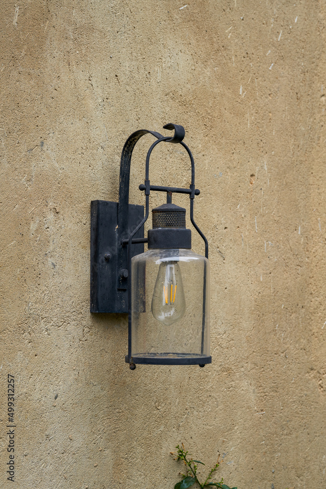 Close-up of incandescent street lamp installed on the wall outdoors Close-up of incandescent street lamp installed on the wall outdoors