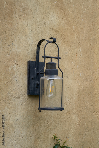 Close-up of incandescent street lamp installed on the wall outdoors