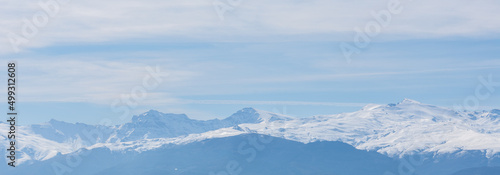 Panoramic view of Sierra Nevada (Granada, Spain) completely covered in snow, with its three peaks over 3000 meters (Mulhacén, Veleta and Alcazaba)
