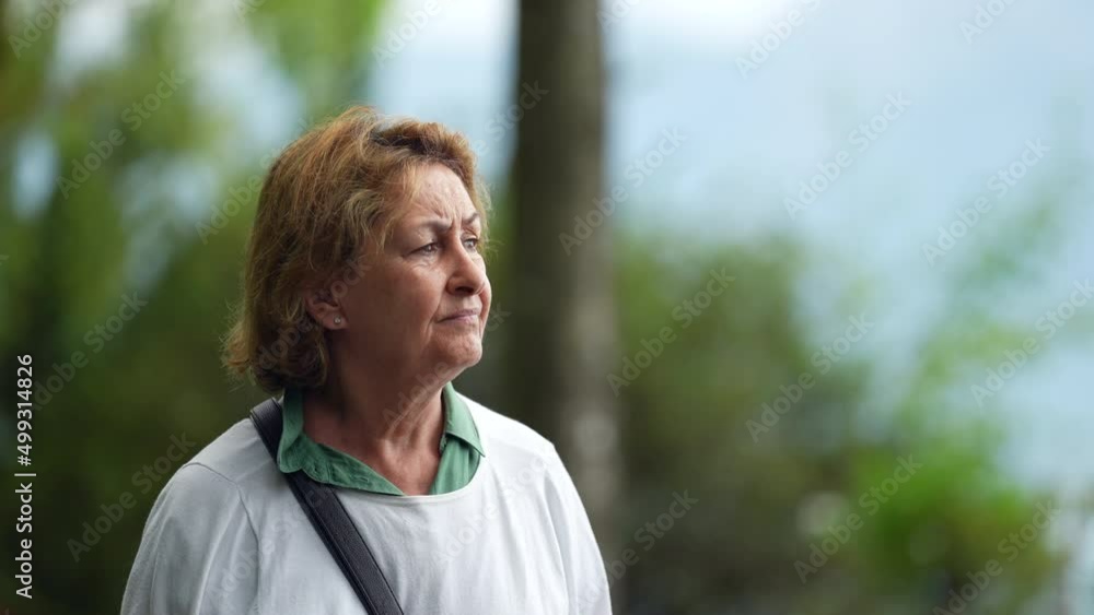 Portrait of a senior woman walking outside in park nature Portrait of a senior woman walking outside in park nature