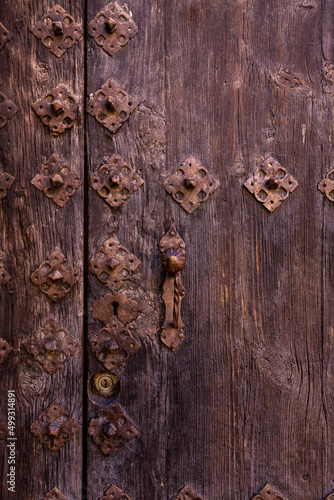old wooden door with old and rusty iron lock