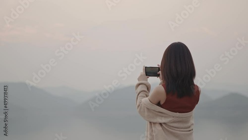 Wallpaper Mural Beautiful girl taking a photo of mountain and dam via her mobile phone in sunset time. Soft mood and soft focus. Torontodigital.ca