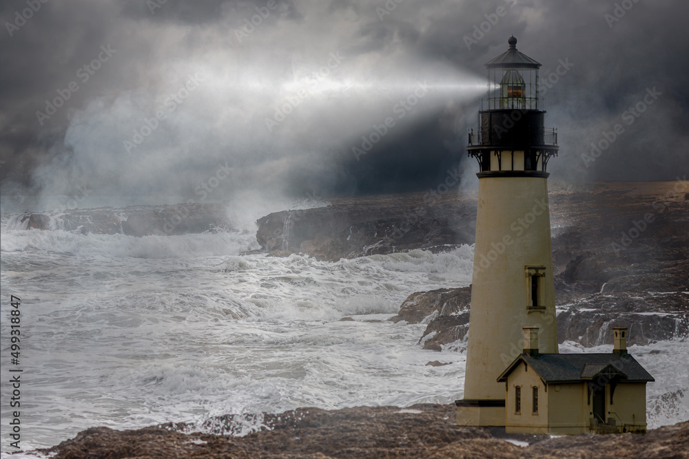 a tall whit lighthouse shinning light at night in a storm with a rough ocean and fog