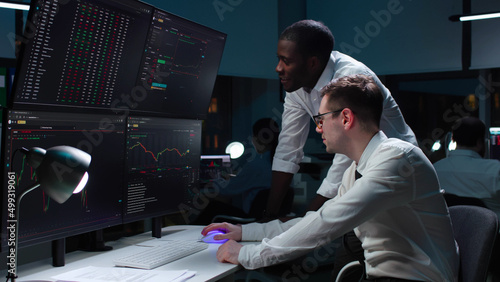 Team of it programmers working on desktop computers in data center control room.  photo