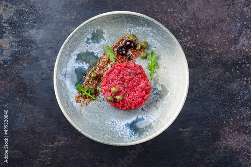 Fotografie Modern style gourmet tartar raw from beef filet with capers and amarena cherry s