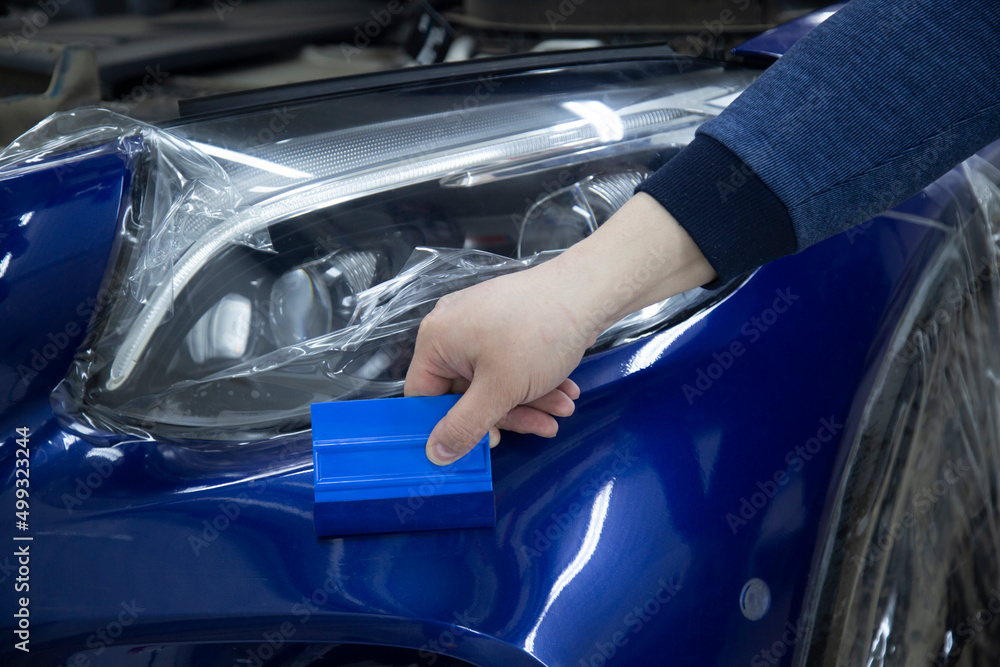 Installing a protective film on the car.Protection of the paintwork of the car. Installing a protective film on the car.Protection of the paintwork of the car.