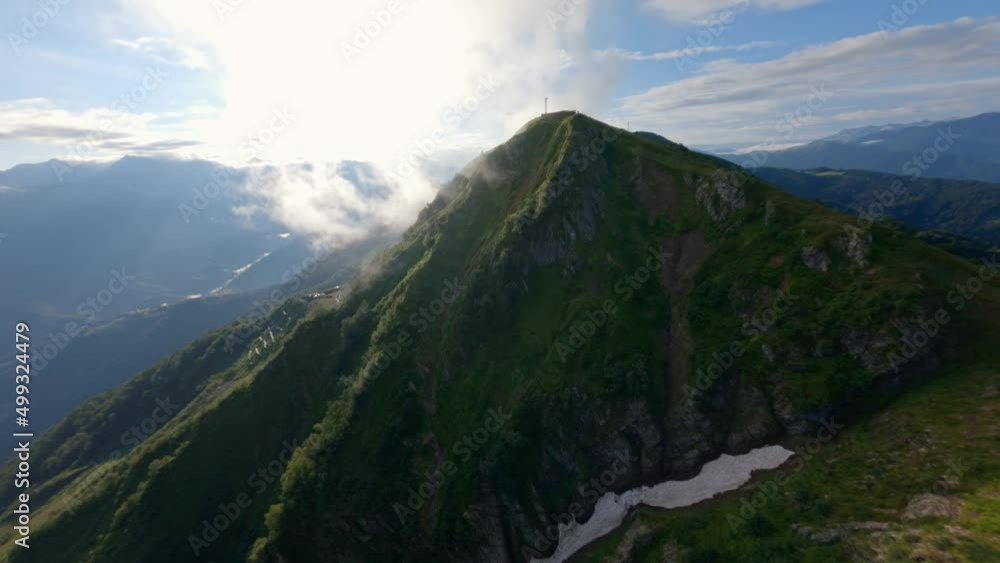 Aerial view flight over cinematic mountain ridge covered by green grass with natural smoke clouds forecast weather. Shooting from FPV drone flying movement cliff organic wild environment hilly terrain Aerial view flight over cinematic mountain ridge covered by green grass with natural smoke clouds forecast weather. Shooting from FPV drone flying movement cliff organic wild environment hilly terrain