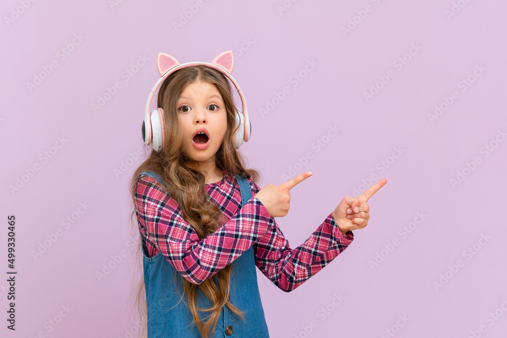 A girl with headphones is pointing at your ad on an isolated background. A girl with headphones is pointing at your ad on an isolated background.