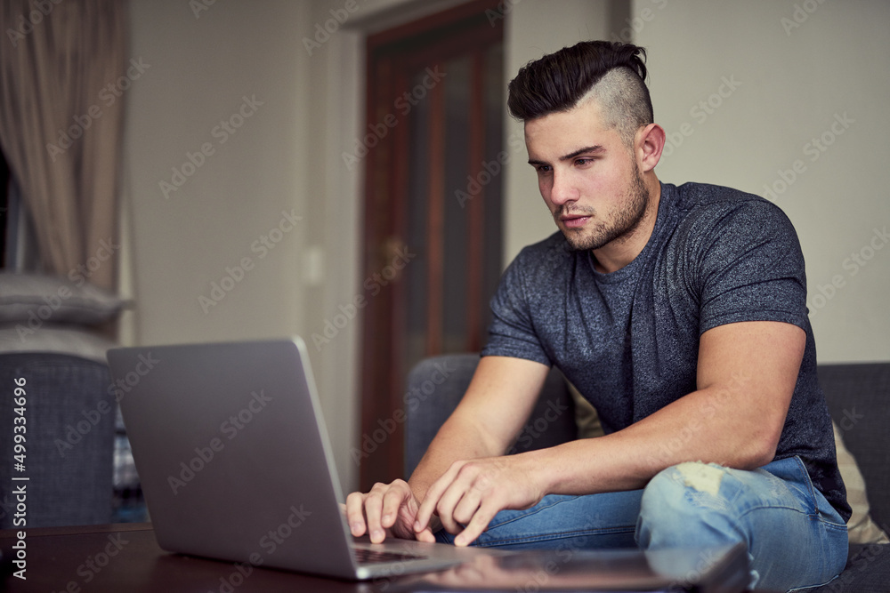 You dont get ahead by taking weekends off. Shot of a driven young man using his laptop to work from home.