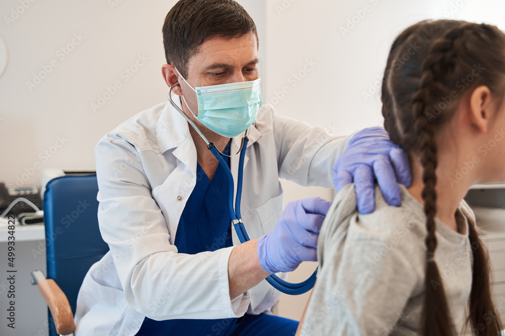 Little girl and young male doctor in hospital having examination Little girl and young male doctor in hospital having examination
