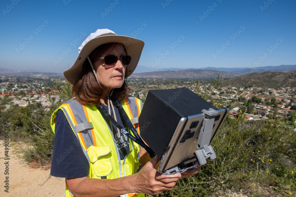 Yucaipa, California, April 14, 2022: A Woman Certified Part 107 FAA Drone Pilot Conducting an Aerial UAV Survey of a Housing Project