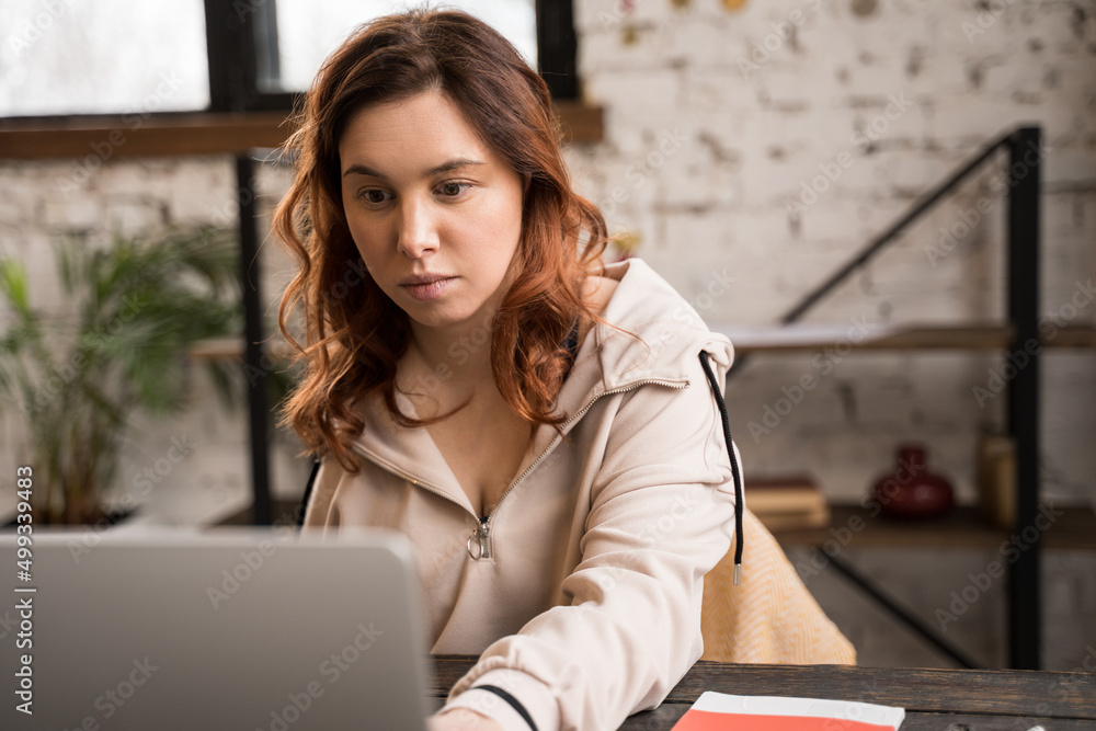 Serious woman without limb working at the laptop computer with serious face Serious woman without limb working at the laptop computer with serious face