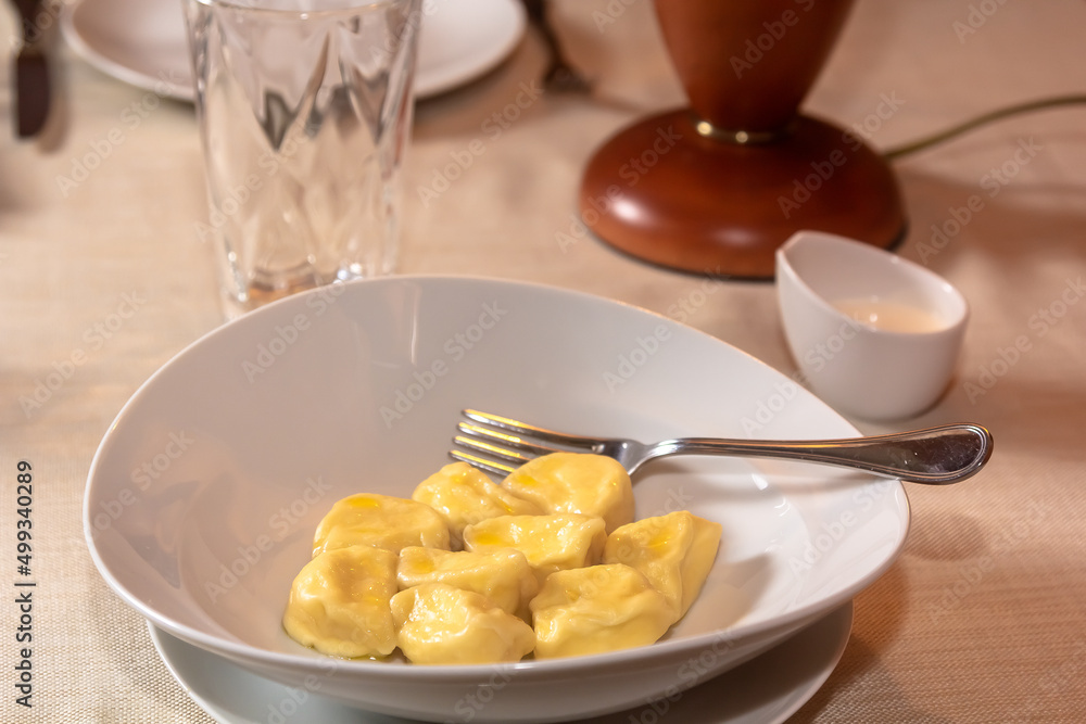 Traditional pelmeni, ravioli, dumplings filled with meat on plate, russian kitchen