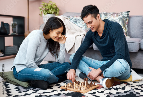 Beat the lockdown blues with a fun board game. Shot of a young couple playing a game of chess at home.
